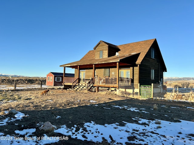 8 S Kicking Bird Rd, Pinedale, WY 82941 - snow covered house featuring covered porch and an outdoor structure