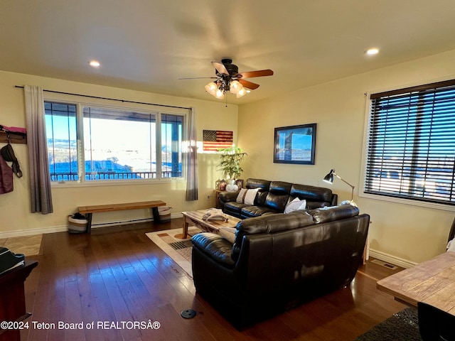 living room featuring dark wood-type flooring and ceiling fan