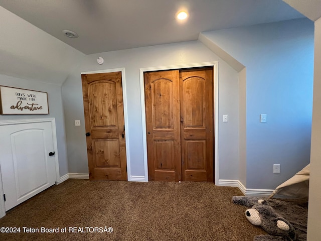 unfurnished bedroom with lofted ceiling and carpet floors