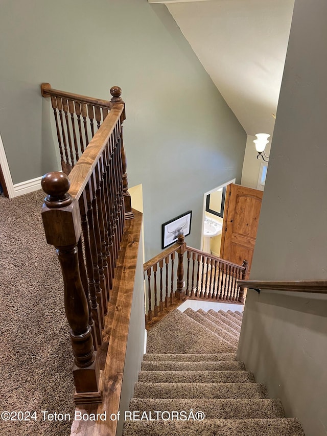 stairs with high vaulted ceiling and carpet floors