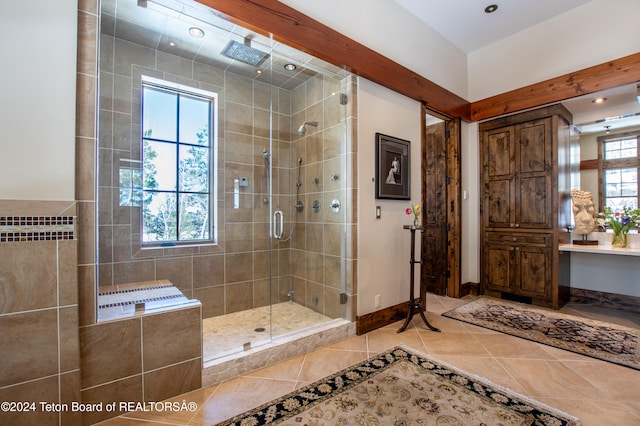 bathroom featuring tile patterned flooring, a wealth of natural light, vanity, and a shower with door