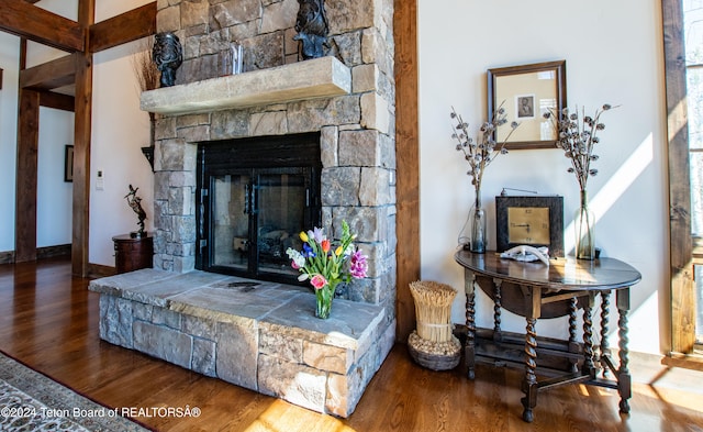 living room featuring a stone fireplace and hardwood / wood-style floors