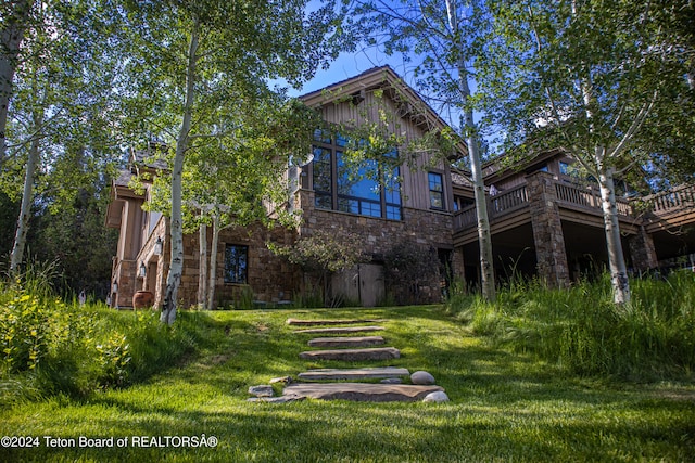 rear view of property featuring a lawn