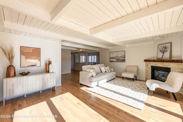 living room with beamed ceiling, wood ceiling, hardwood / wood-style floors, and a fireplace