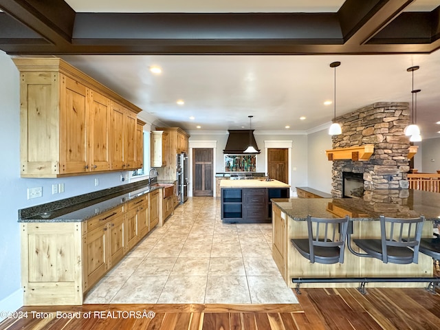 kitchen with premium range hood, dark stone countertops, a spacious island, and decorative light fixtures