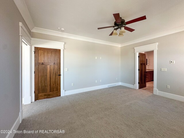 empty room featuring light colored carpet, ceiling fan, and crown molding