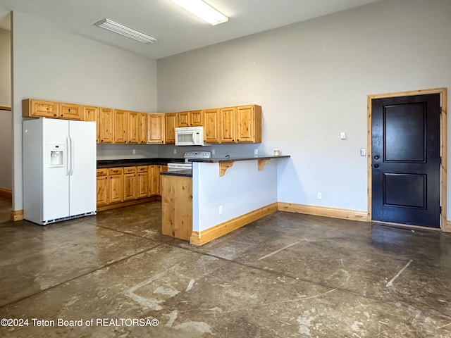 kitchen featuring a kitchen breakfast bar, kitchen peninsula, a high ceiling, and white appliances