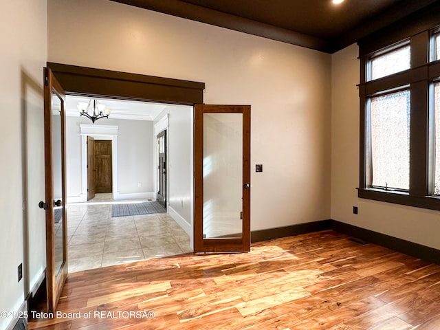 81 Twin Cliffs Rd, Afton, WY 83110 - unfurnished room with french doors, a chandelier, light wood-type flooring, and ornamental molding