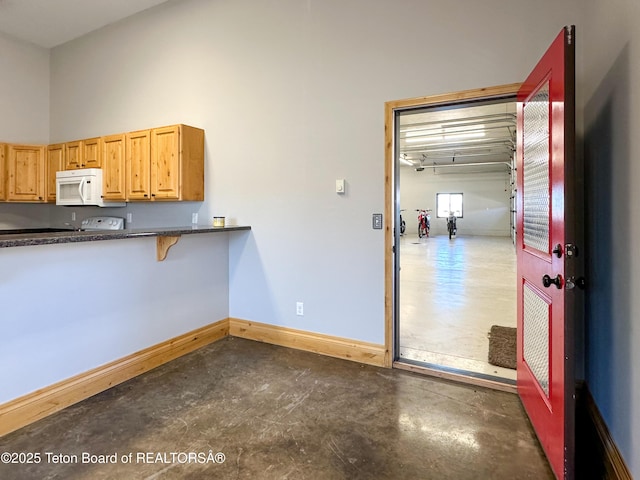 81 Twin Cliffs Rd, Afton, WY 83110 - kitchen featuring white microwave, concrete floors, and dark countertops