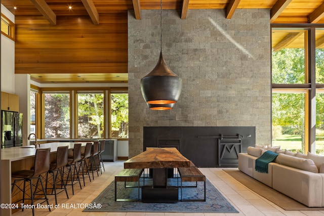 tiled dining area with beamed ceiling, plenty of natural light, wood ceiling, and sink