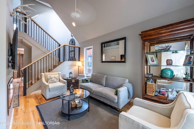 living room with high vaulted ceiling and light hardwood / wood-style flooring