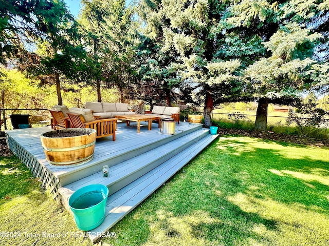 wooden terrace with an outdoor living space and a yard