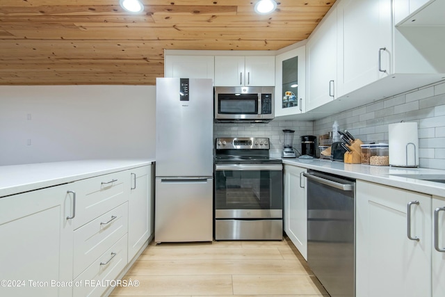 kitchen with light hardwood / wood-style flooring, tasteful backsplash, white cabinetry, stainless steel appliances, and wood ceiling