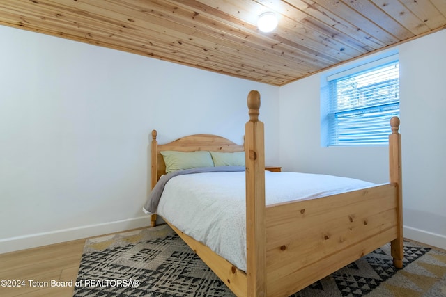 bedroom with hardwood / wood-style floors, wooden ceiling, and ornamental molding