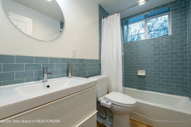 full bathroom featuring shower / bath combination with curtain, vanity, toilet, and tile walls