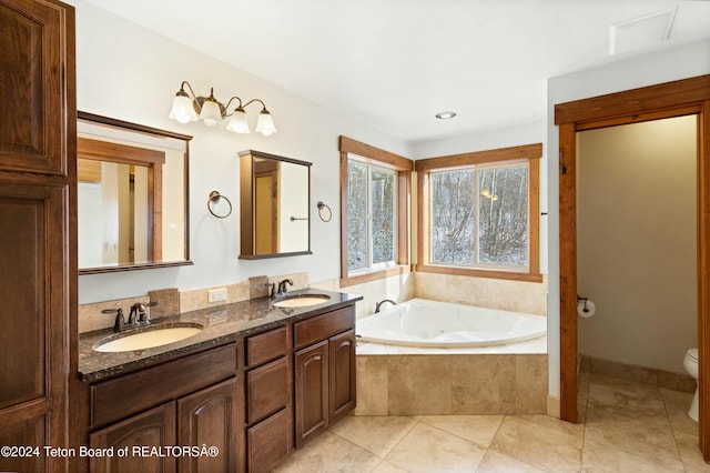 bathroom featuring tile patterned floors, vanity, toilet, and tiled tub