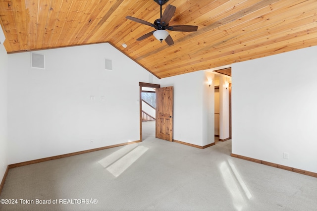 spare room featuring light carpet, vaulted ceiling, ceiling fan, and wooden ceiling