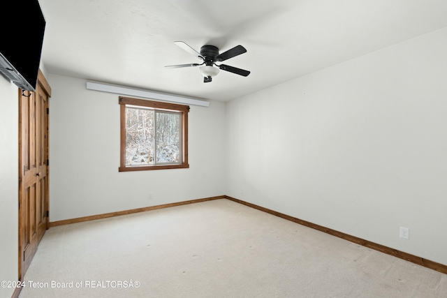 unfurnished bedroom featuring ceiling fan, light colored carpet, and a closet