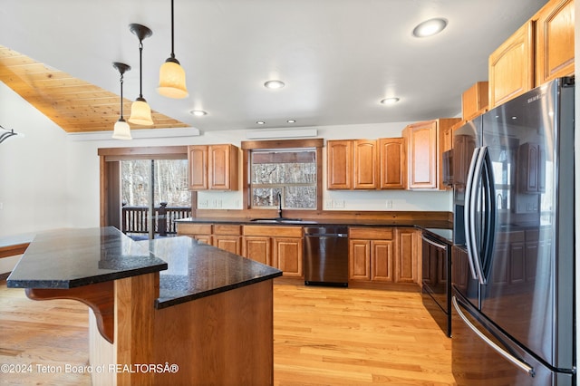 kitchen with stainless steel refrigerator with ice dispenser, sink, pendant lighting, light hardwood / wood-style flooring, and a center island