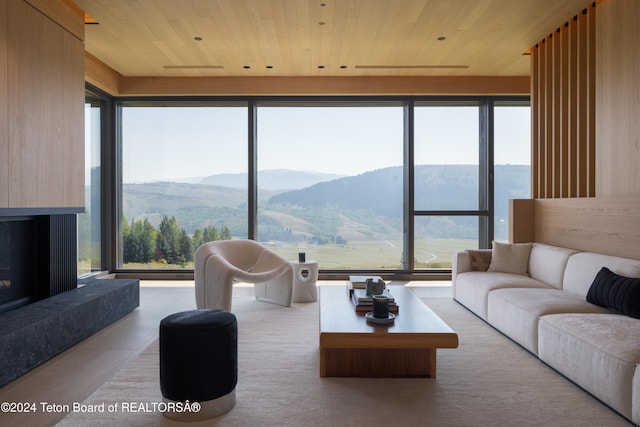 living room with a fireplace, wood ceiling, and a mountain view