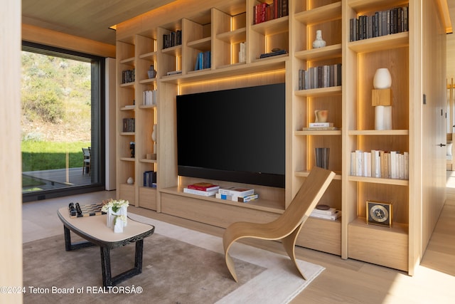 living room featuring light wood-type flooring, wood ceiling, and built in shelves