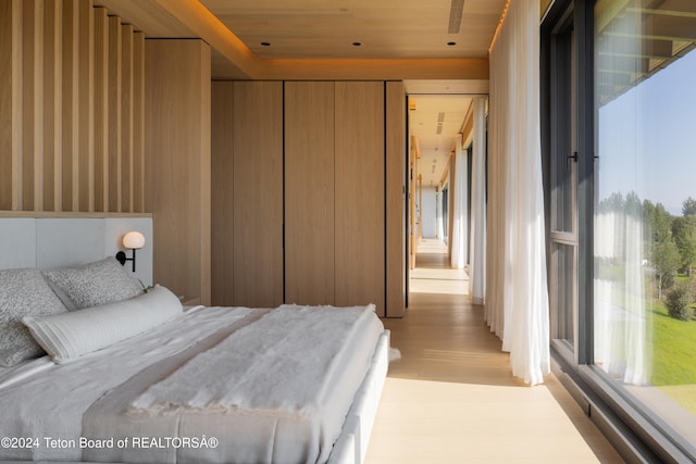 bedroom featuring light hardwood / wood-style floors and wooden ceiling