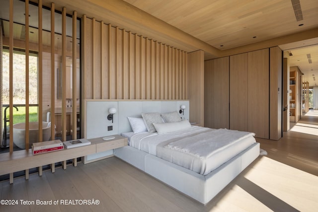 bedroom with light hardwood / wood-style flooring and wood ceiling