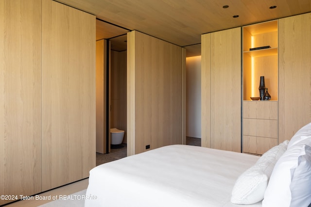 bedroom featuring connected bathroom and wood ceiling