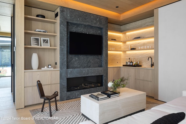 living room with a fireplace, light hardwood / wood-style flooring, and built in shelves