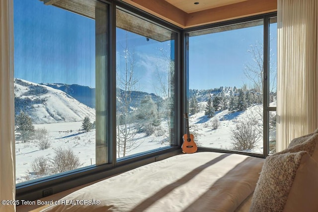 bedroom with a mountain view and multiple windows