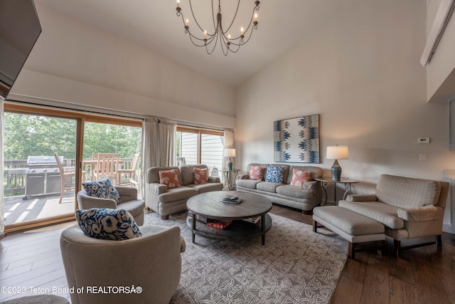 living room featuring wood-type flooring, high vaulted ceiling, and an inviting chandelier