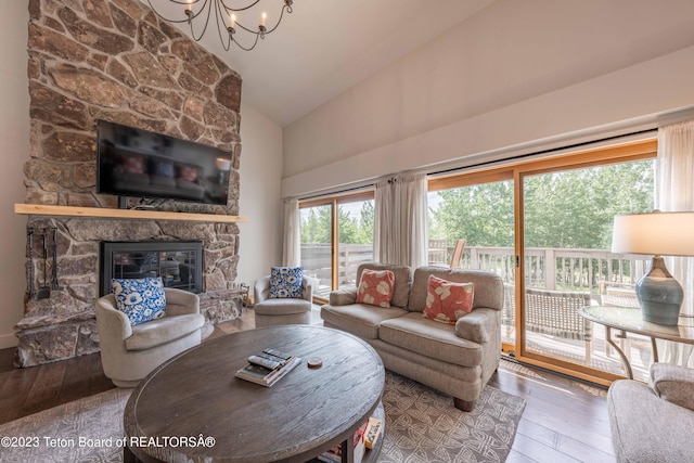 living room with a fireplace, high vaulted ceiling, a chandelier, and hardwood / wood-style flooring