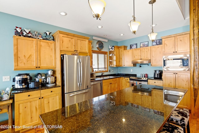 kitchen with appliances with stainless steel finishes, sink, light brown cabinets, dark stone countertops, and hanging light fixtures