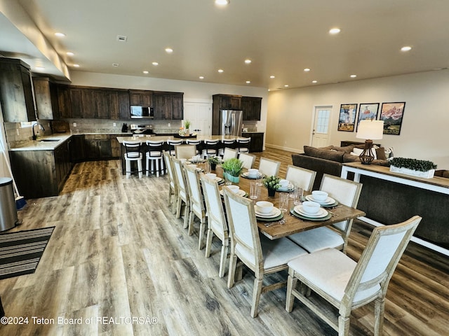 dining space with light wood-type flooring and sink