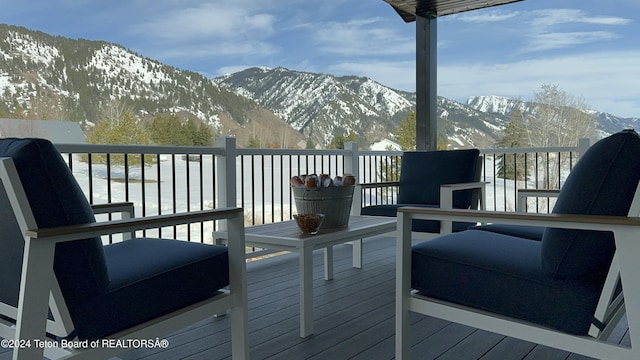 snow covered deck with a mountain view