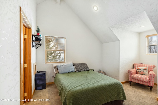 carpeted bedroom featuring a textured ceiling and vaulted ceiling