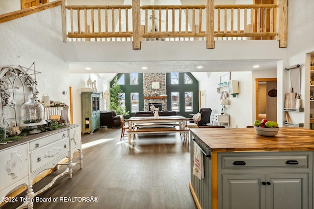 kitchen featuring butcher block countertops, gray cabinets, a fireplace, and a high ceiling