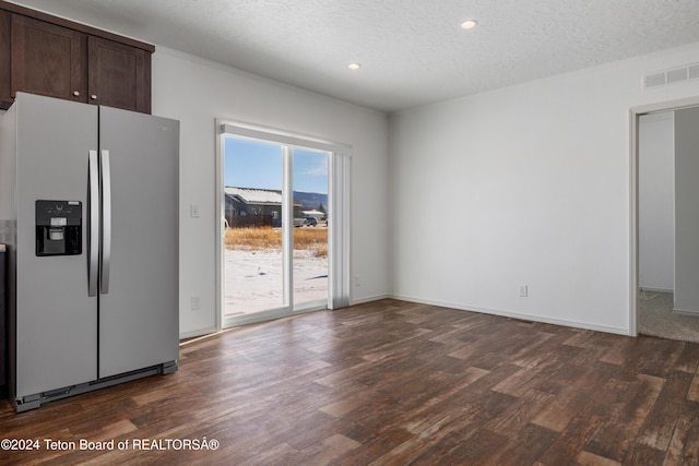 kitchen with stainless steel refrigerator with ice dispenser, dark brown cabinetry, a textured ceiling, and dark wood-type flooring