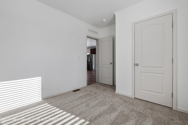 3829 Spruce Rd, Driggs, ID 83422 - unfurnished bedroom featuring carpet flooring, stainless steel fridge with ice dispenser, and ornamental molding