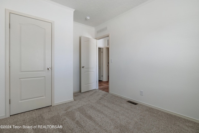 3829 Spruce Rd, Driggs, ID 83422 - unfurnished bedroom with carpet flooring, crown molding, and a textured ceiling