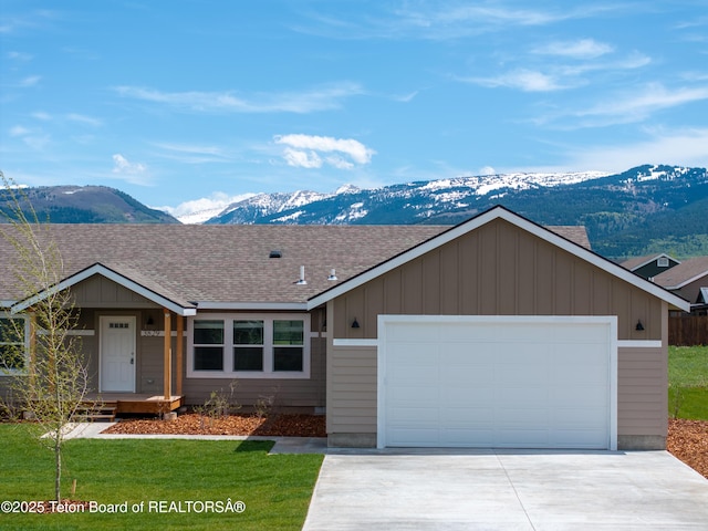 3829 Spruce Rd, Driggs, ID 83422 - ranch-style house with a mountain view, concrete driveway, roof with shingles, board and batten siding, and a garage