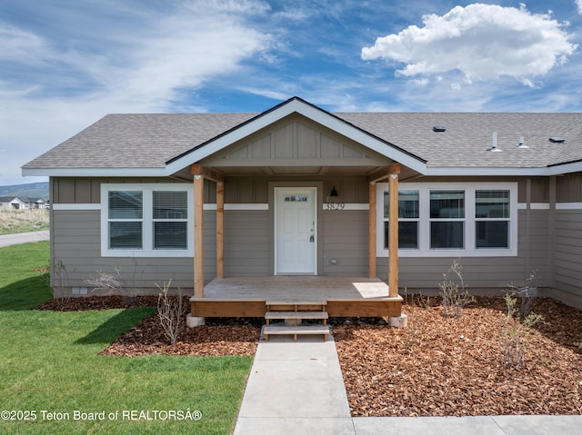 3829 Spruce Rd, Driggs, ID 83422 - bungalow featuring a shingled roof, board and batten siding, covered porch, and a front lawn