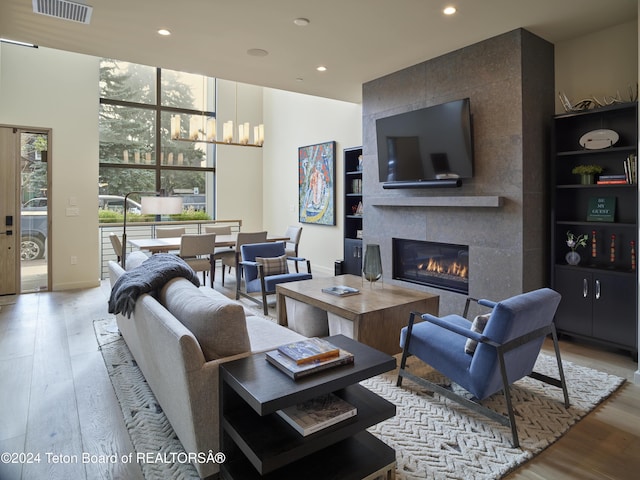 living room featuring a tile fireplace and light hardwood / wood-style flooring