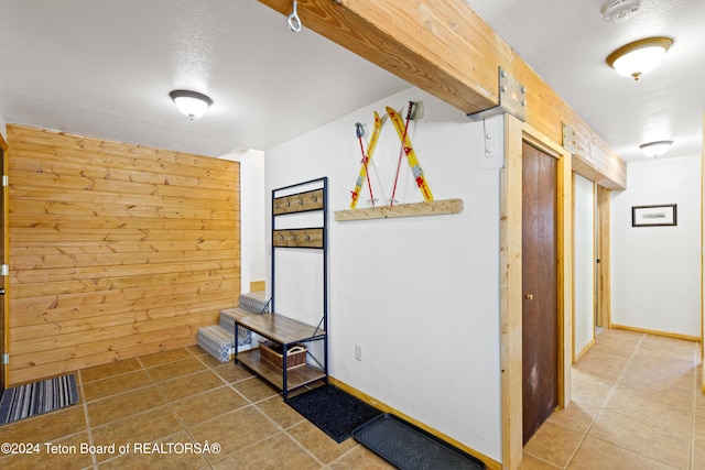 corridor with tile patterned floors and wood walls