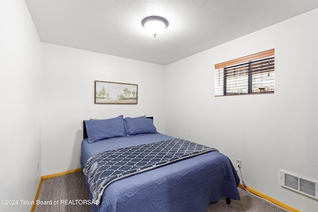 bedroom featuring carpet flooring and a textured ceiling