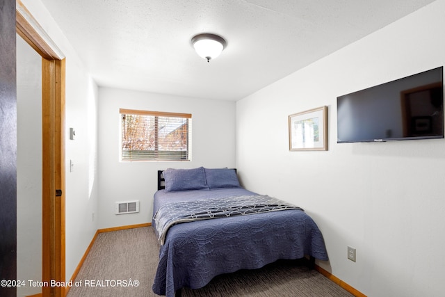 bedroom featuring carpet flooring and a textured ceiling