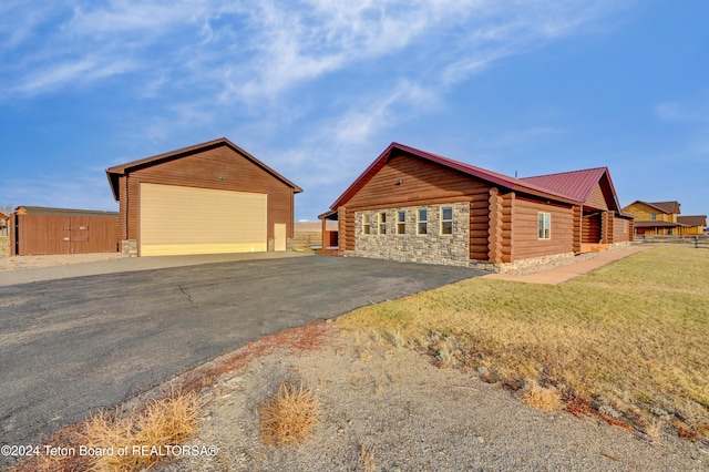 view of front of home with an outbuilding, a garage, and a front lawn