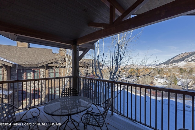 snow covered deck with a mountain view