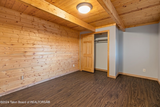 unfurnished bedroom featuring beamed ceiling, dark hardwood / wood-style floors, wooden ceiling, and a closet