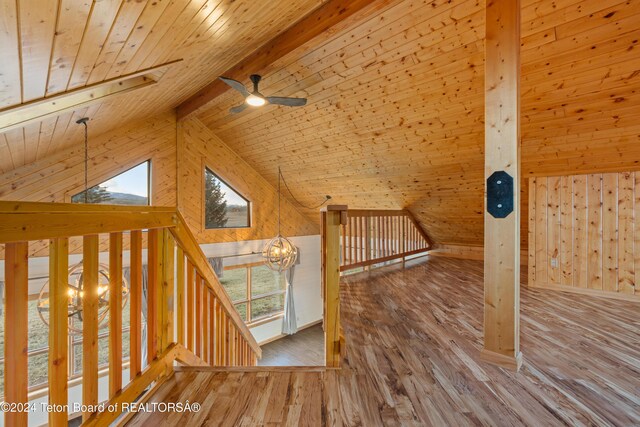 bonus room featuring wooden walls, hardwood / wood-style flooring, vaulted ceiling with beams, ceiling fan, and wood ceiling